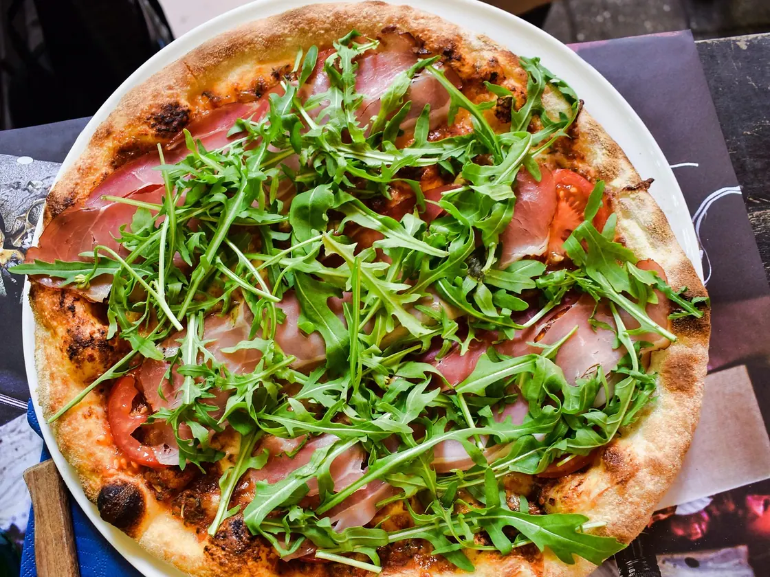 Pizza de jamón serrano, rúcula y parmesano